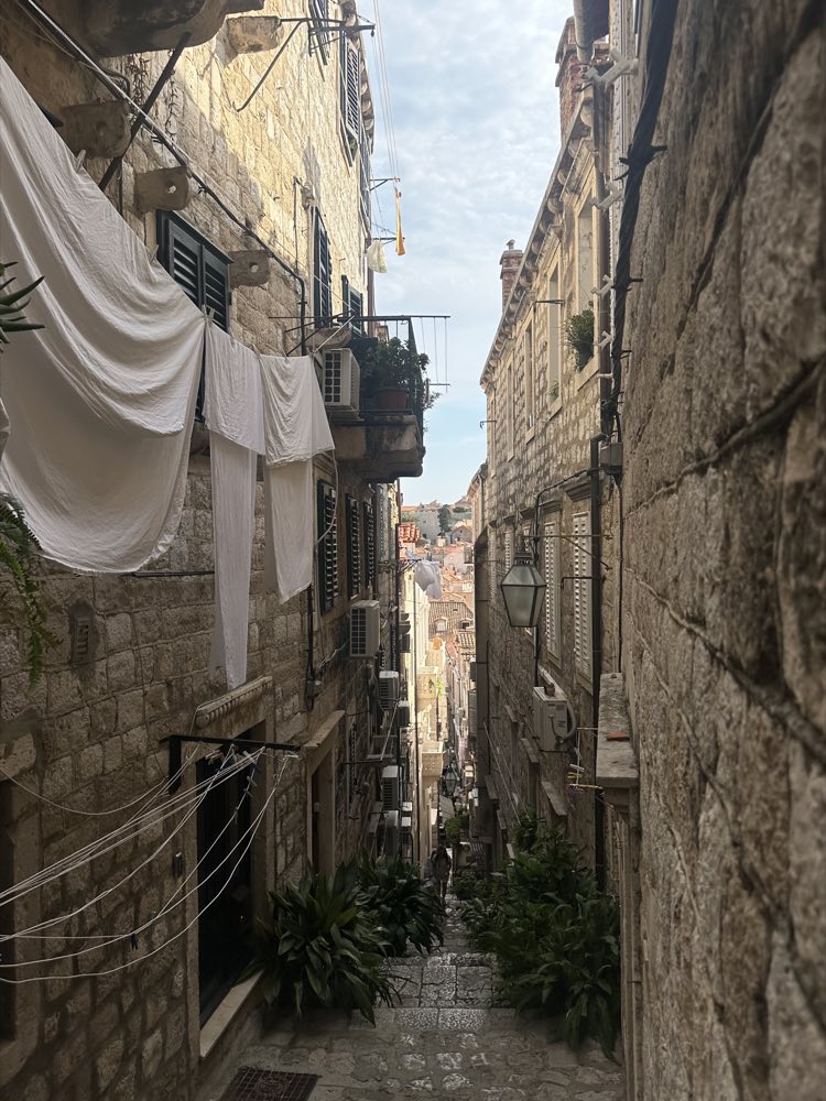 A narrow Dubrovnik stone alley with laundry strung between houses