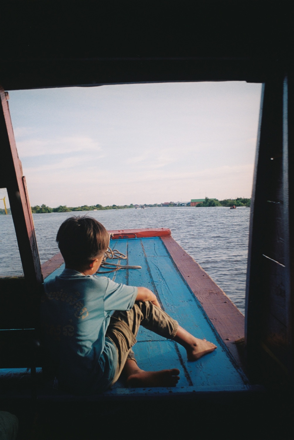 A boy looking out from a boat over the water