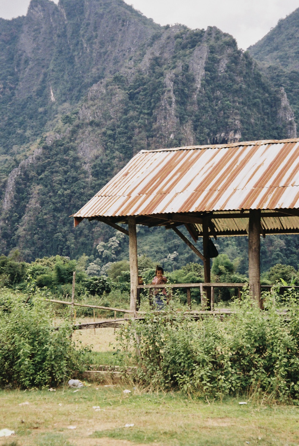 A tin-roofed shelter below karst mountains