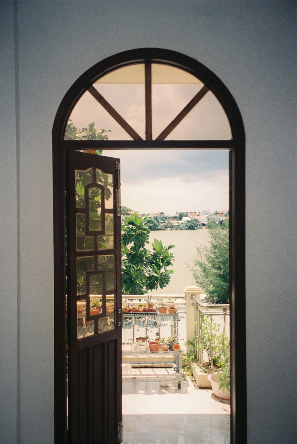 An arched doorway opening onto a balcony over water