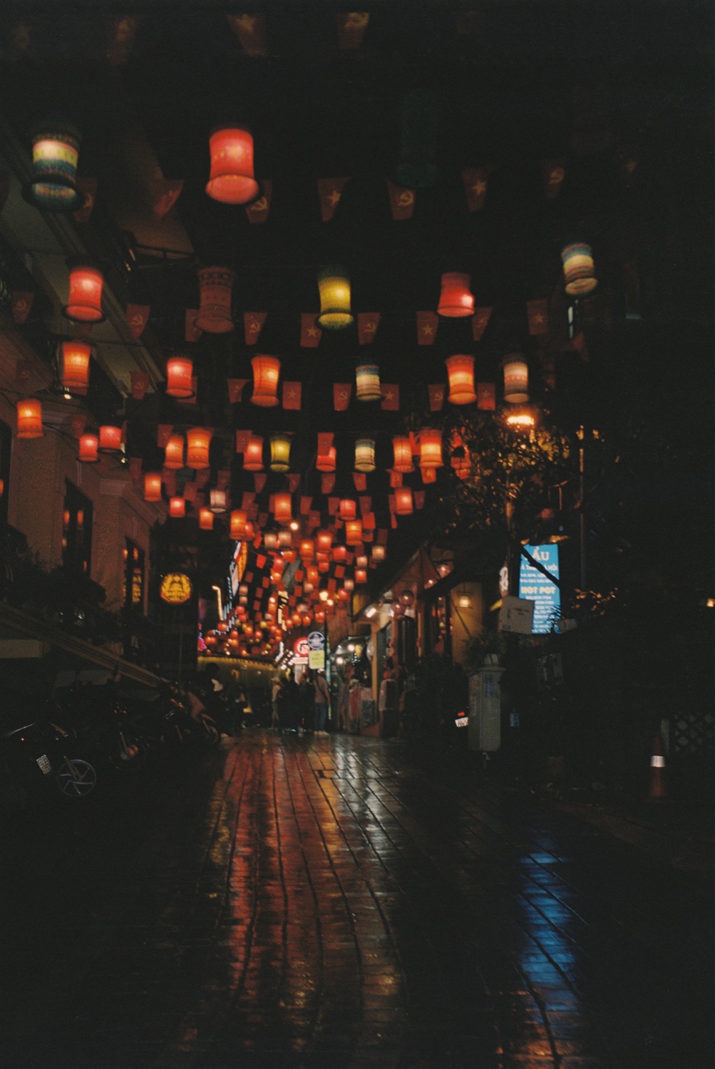 A lantern-lit street reflected on wet stone