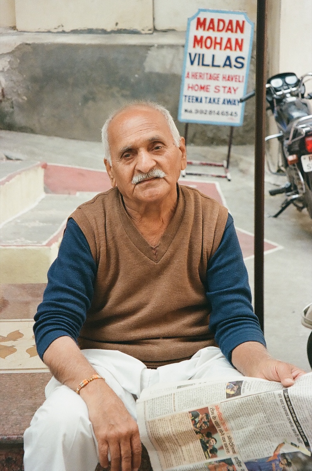 A man with a newspaper outside Madan Mohan Villas