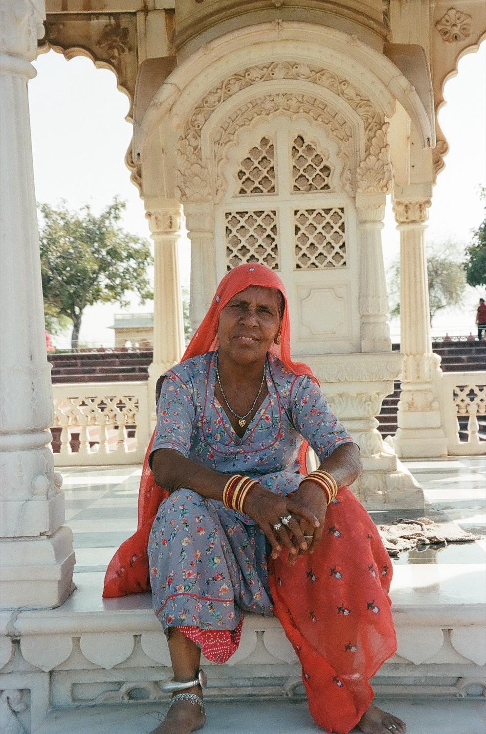 A woman seated in a white marble pavilion